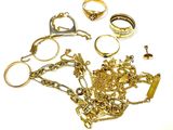 a lot of gold jewelry on a white surface