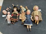 several antique dolls are lined up on a black surface