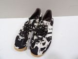 black and white cow print sneakers with laces on a white surface