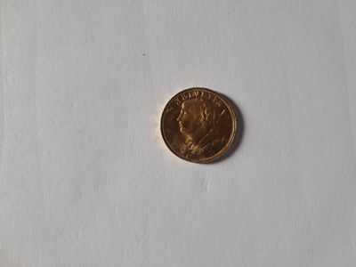 a close up of a penny sitting on a white surface