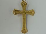 a close up of a gold cross on a white surface