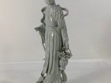 statue of a woman with a basket of flowers in her hand