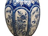 a blue and white vase with a bird and flowers on it