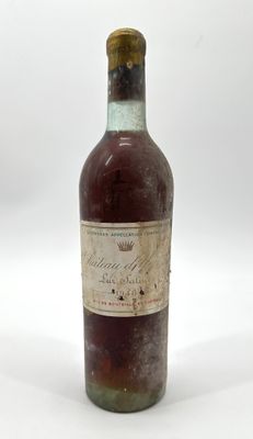 une vieille bouteille de vin posée sur une surface blanche