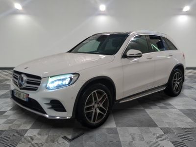 Une Mercedes GLC blanche est garée sur un sol à damier