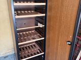 an open refrigerator with a bunch of bottles of wine inside of it