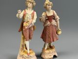 deux figurines d'un homme et d'une femme debout l'un à côté de l'autre