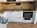 a small kitchen with white cabinets and a black stove top oven