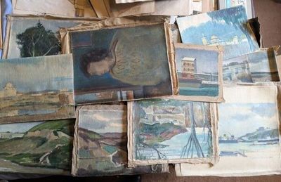 une pile de tableaux posée sur une table dans une pièce