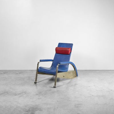 un fauteuil à bascule bleu et rouge dans une pièce blanche