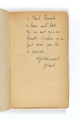 un livre ouvert, sur lequel est posée une note manuscrite, posé sur une table
