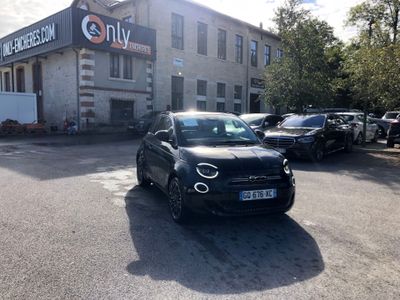 cars parked in a parking lot in front of a building with a sign on it