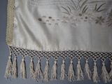 an image of a close up of a table cloth with tassels on it