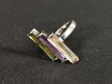 a close up of a ring with two different colored stones on it