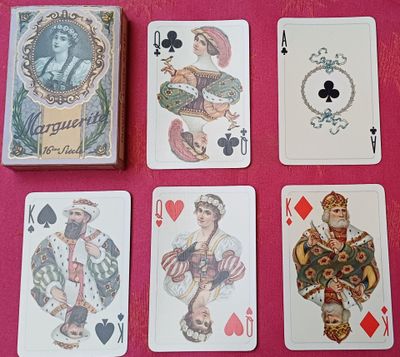quatre jeux de cartes posés sur une table recouverte d'une nappe rose