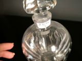 a person holding a bottle of perfume on a table