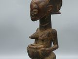 un gros plan sur la statue d'une personne tenant un bol
