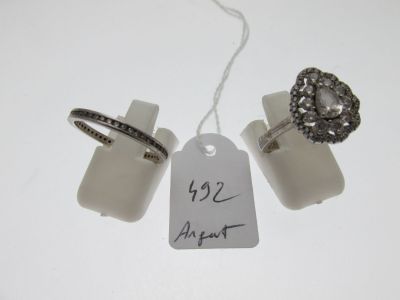 two rings and a ring with a price tag on a white background