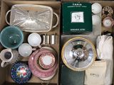 une boîte remplie d'objets divers, notamment de vaisselle, de tasses, d'assiettes et de bols