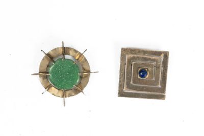 a small metal object with a green stone in it