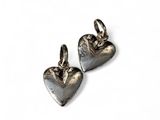 a pair of silver heart charms on a white background