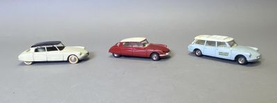 trois voitures jouets assises l'une à côté de l'autre sur une table