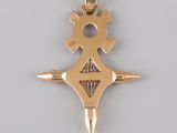 an image of a gold pendant with a cross on it