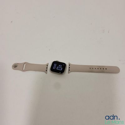 Une Apple Watch est posée sur une surface blanche, avec un bracelet autour.