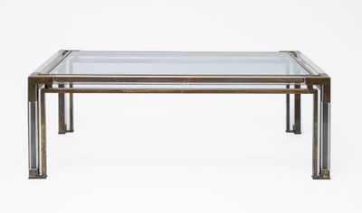 a glass and brass coffee table on a white background