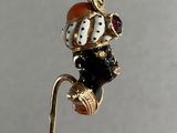 a gold stick with a black and white figurine sitting on top of it