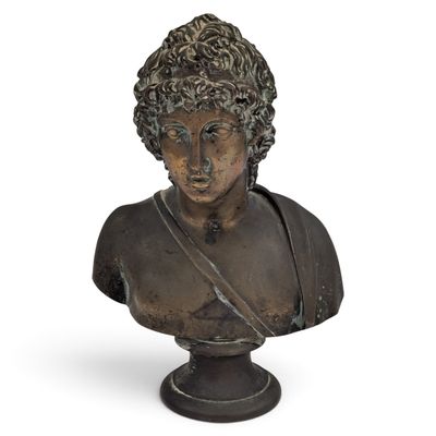 un vieux buste en bronze représentant un homme aux cheveux bouclés, sur fond blanc