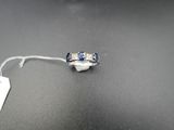 une photo d'une bague sertie d'un diamant et d'un saphir, avec une étiquette de prix accrochée dessus