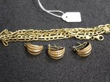 a close up of a gold chain bracelet with three charms