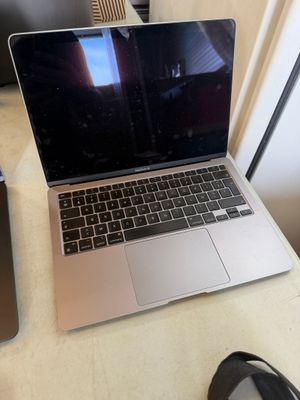 a laptop computer sitting on top of a desk next to a pair of shoes