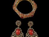 a gold and coral bracelet, ring, and earring