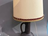 une lampe posée sur une table à côté d'un vase