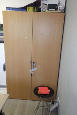 une petite table avec un tabouret devant une armoire