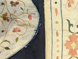 two pieces of cloth with designs on them on a table