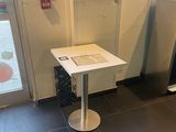 une petite table sur laquelle est posé un livre, dans un coin de la pièce