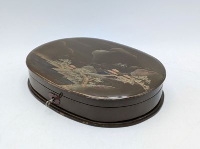 une boîte noire ornée d'une peinture, posée sur une surface blanche