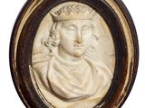 un gros plan sur un médaillon sculpté représentant un homme coiffé d'une couronne