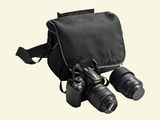 a black camera bag with two cameras attached to it