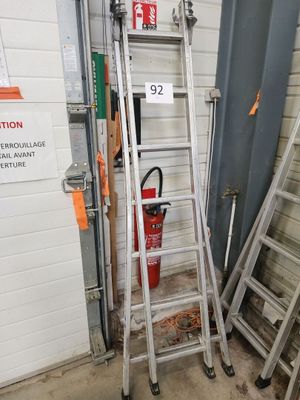 une échelle appuyée contre un mur, à côté d'un extincteur