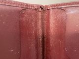 someone is holding a brown leather purse with a zipper on it