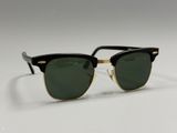 a pair of black and gold sunglasses on a white surface