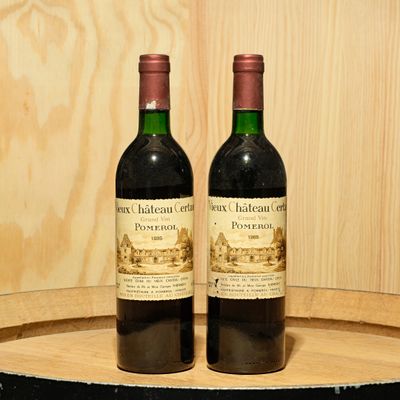 two bottles of wine sitting on top of a barrel