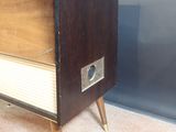 an old fashioned television sitting on a stand in a room