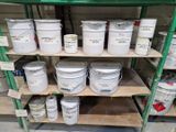 de nombreux seaux de peinture sur les étagères du magasin