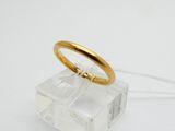 une photo d'une bague en or posée sur une boîte transparente
