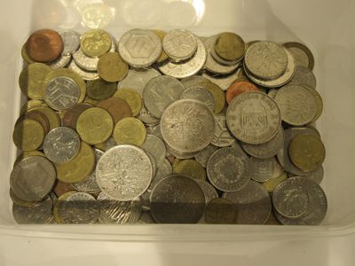 un récipient en plastique rempli de pièces de monnaie posé sur une table